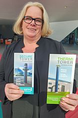 Frau hält zwei Flyer in die Kamera