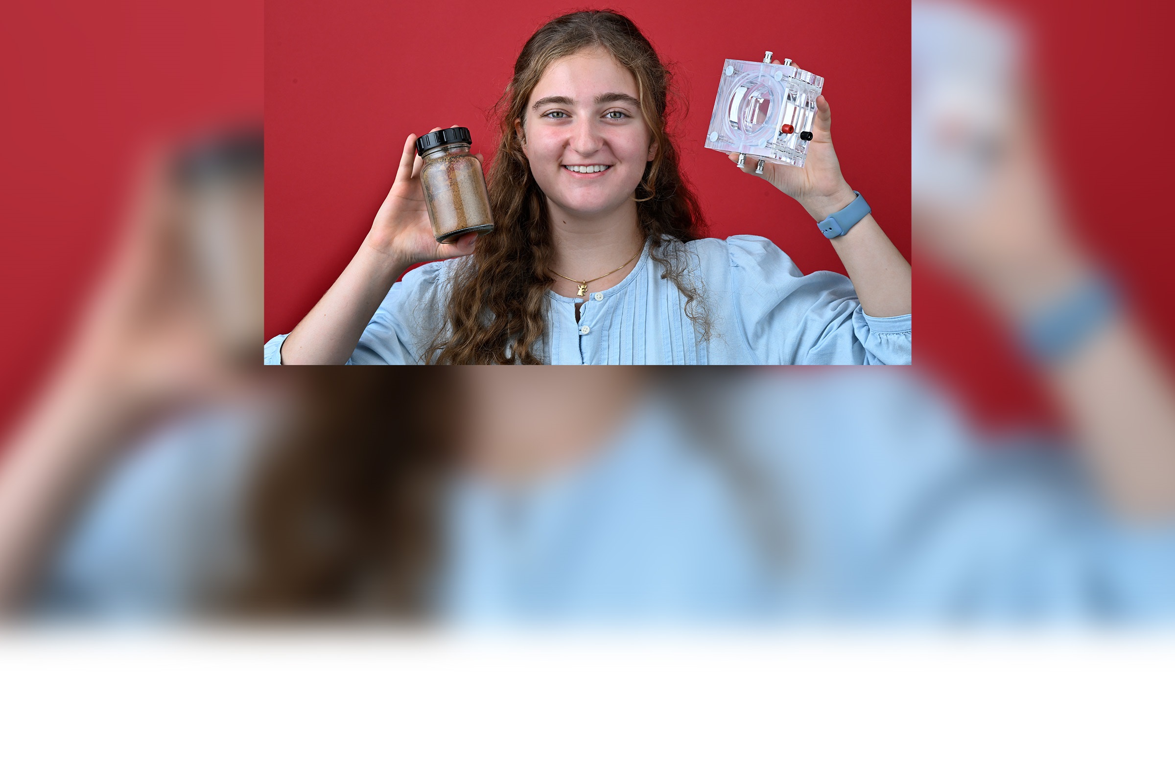 Junge Frau hält Glasbehälter mit organischem Material und galvanische Zelle in den Händen