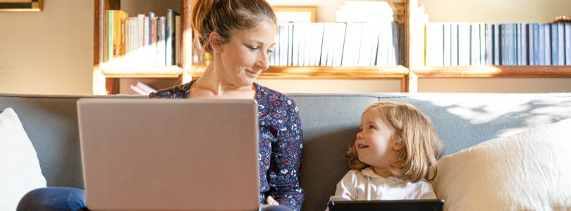 Mother and daughter on sofa with computer