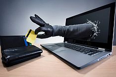 Black hand comes out of laptop and reaches into wallet