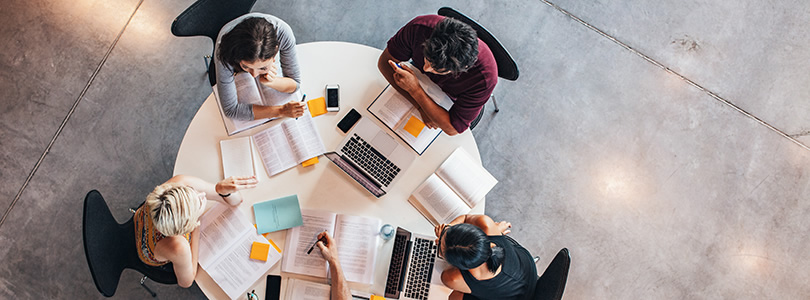 Arbeitende Menschen an einem runden Tisch